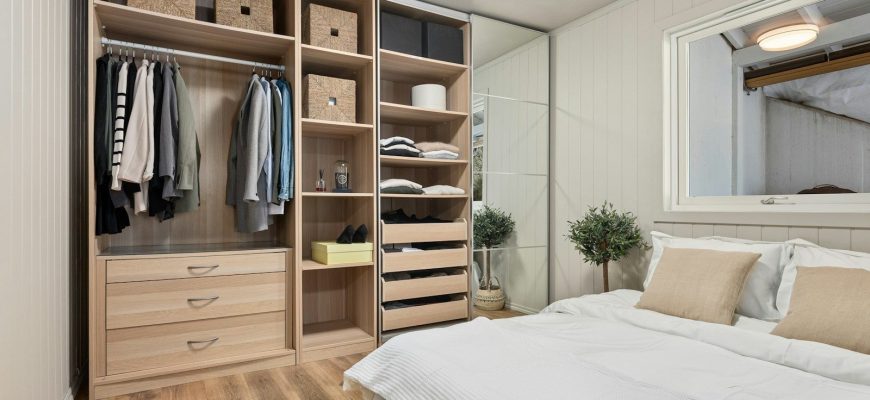 A bedroom with a bed, mirror and closet