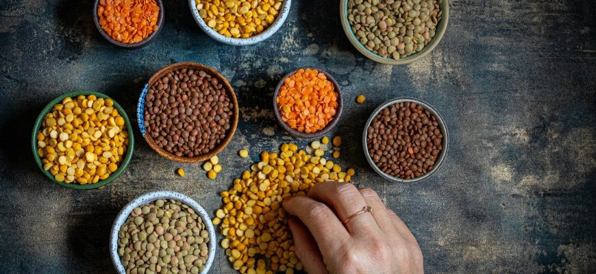 a person touching a bowl of lentils on a table